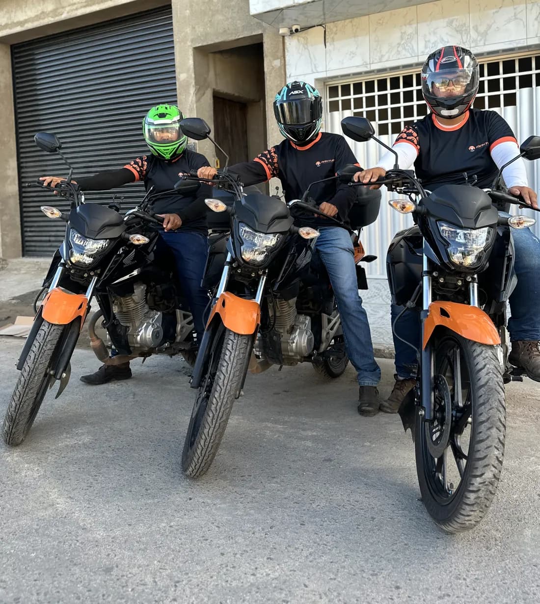 Três integrantes da equipe Maktub em motos, com uniforme da empresa